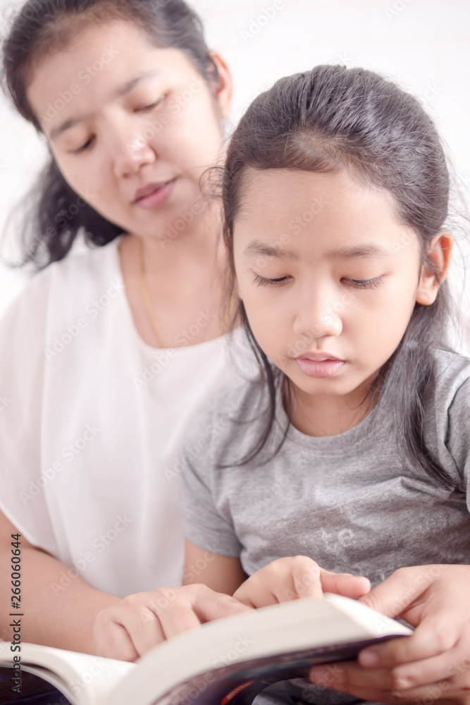 Mom teaching daughter to reading a book Mom teaching daughter to reading a book