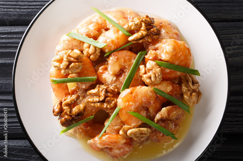 Honey Shrimp are fried with a tempura batter and quickly tossed in a honey sauce and sweetened walnuts close-up. horizontal top view