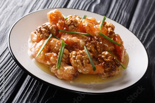 Chinese crispy shrimp tossed in a creamy, sweet sauce topped with caramelized walnuts close-up. horizontal