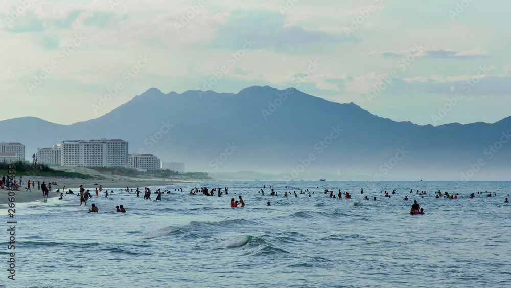 Swimming on the beach in bad cloudy weather against the dark sky and mountains