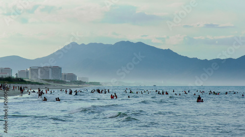 Obraz na płótnie Swimming on the beach in bad cloudy weather against the dark sky and mountains w salonie