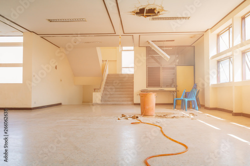 water leak drop interior office building in red bucket from gypsum ceiling and flow on terrazzo floor