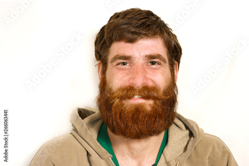 Young man with a red beard smiling over camera photo