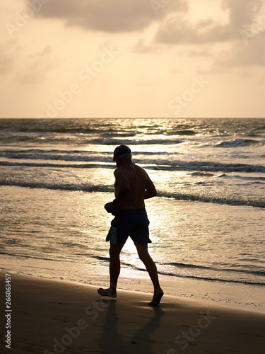 man walking on the beach at sunset