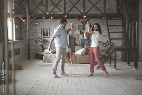 Dad and mom hold children by foots upside down