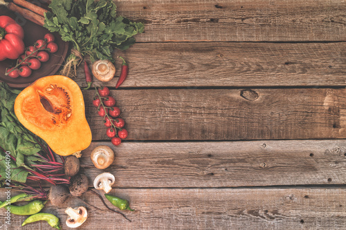 Autumn concept with seasonal vegetables for Thanksgiving Day. Fresh vegetables on dark table. Healthy eating. Squash, bell peppers and onions. Recipes or menu card. Flat lay, copy space. Toned image.