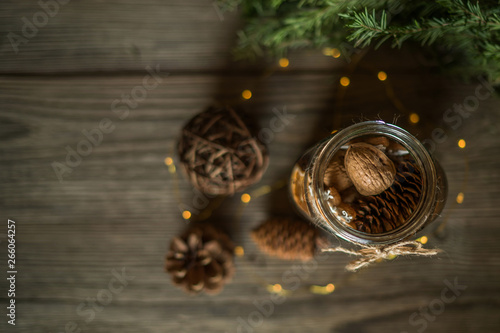 Christmas gift with homemade gingerbread cookies, nuts and chocolates. Glass jar, fir branches, Christmas spices and decor. Winter holidays, New Year or Christmas concept. Top view with copy space.