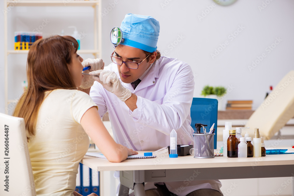 Obraz premium Young woman visting male doctor otolaryngologist