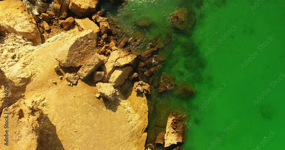 A bird eye view aerial shot of persian gulf rock island line and green water An aerial 4K view of persian gulf green water natural sun light no people and small high rock island A bird eye view aerial shot of persian gulf rock island line and green water An aerial 4K view of persian gulf green water natural sun light no people and small high rock island