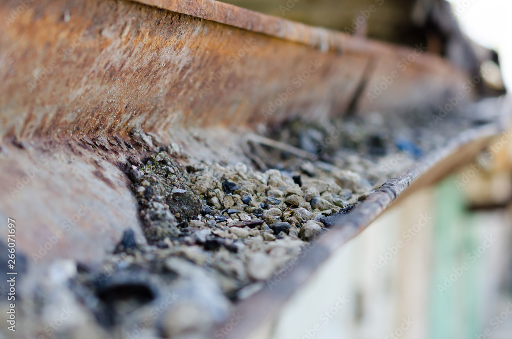 Fototapeta premium Old rusty rain gutter with pebbles