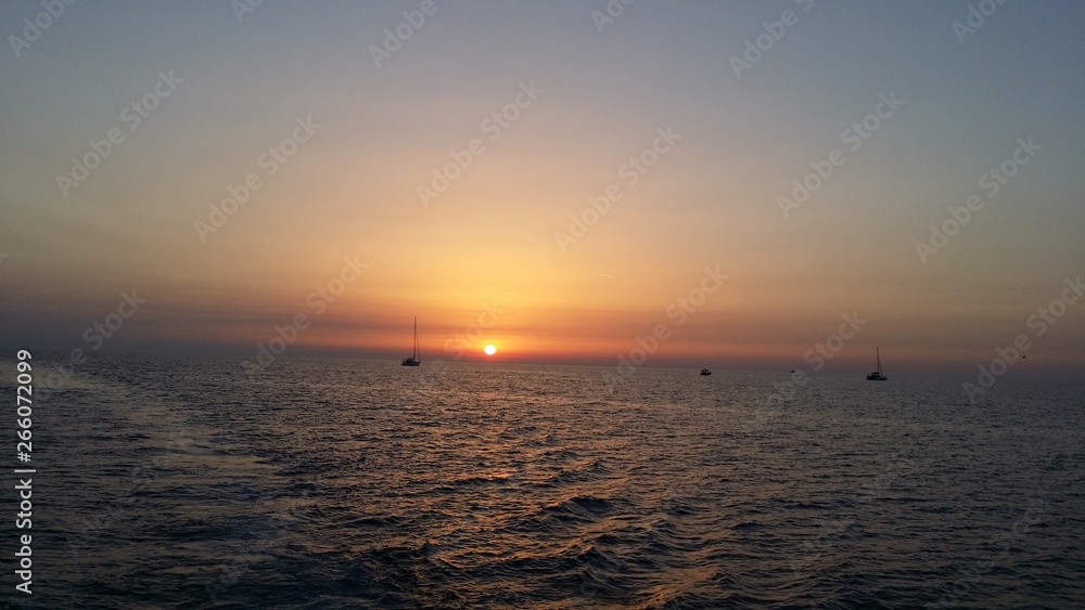 tramonto sul mare con barche sullo sfondo tramonto sul mare con barche sullo sfondo