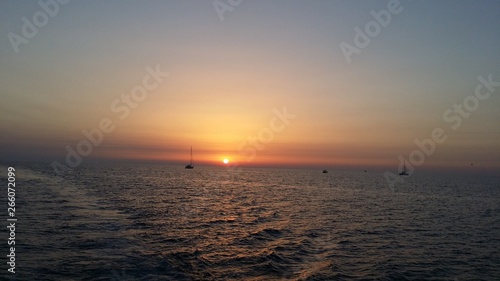 tramonto sul mare con barche sullo sfondo