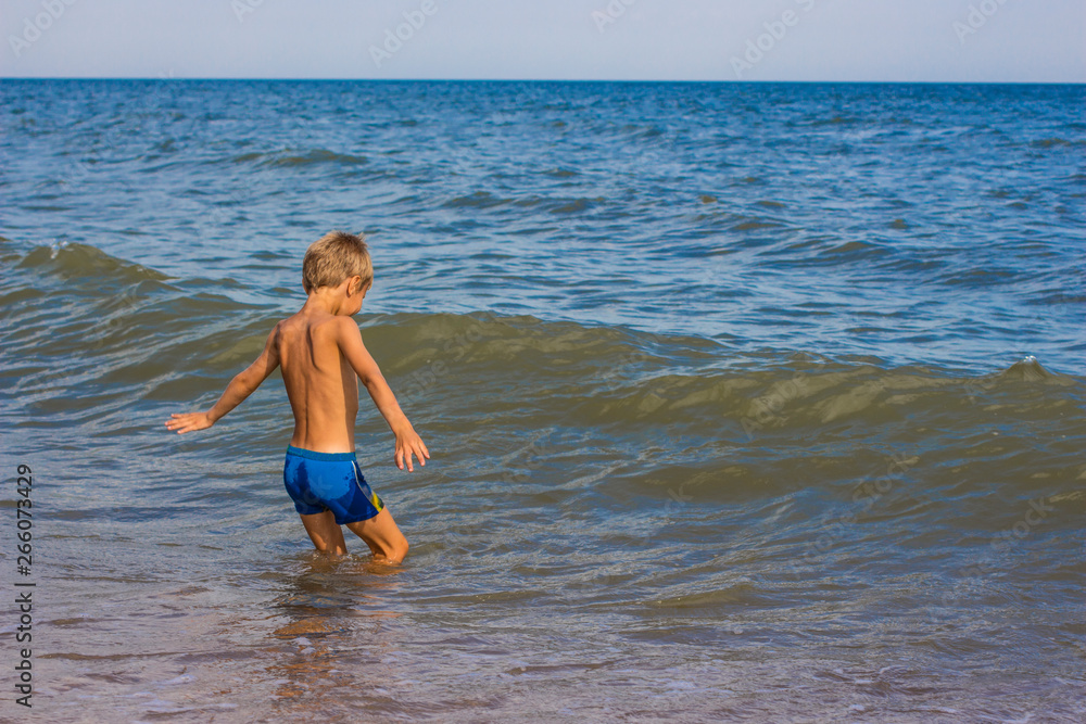 Fototapeta premium The boy is swimming in the sea without hiding joy.