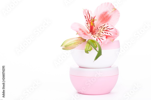 Fototapeta Naklejka Na Ścianę i Meble -  Moisturizer on white background with pink flower 