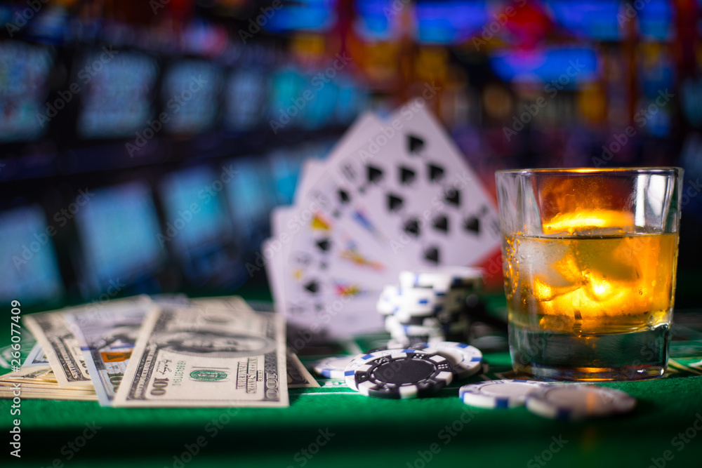 gambling, fortune, game and entertainment concept - close up of casino chips and whisky glass on table gambling, fortune, game and entertainment concept - close up of casino chips and whisky glass on table