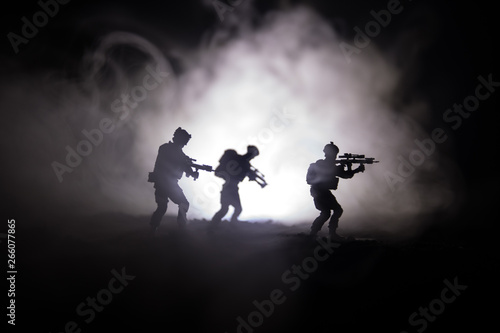 Military soldier silhouette with gun. War Concept. Military silhouettes fighting scene on war fog sky background, World War Soldier Silhouette Below Cloudy Skyline At night.