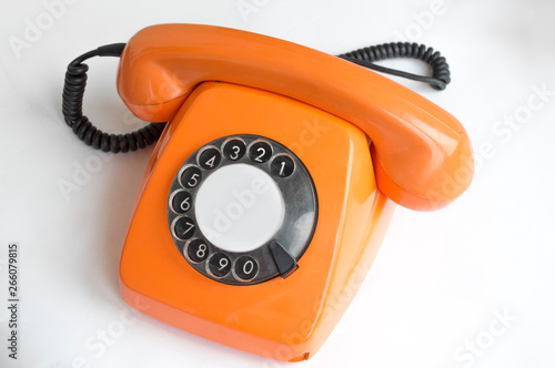 Old orange telephone on a white background