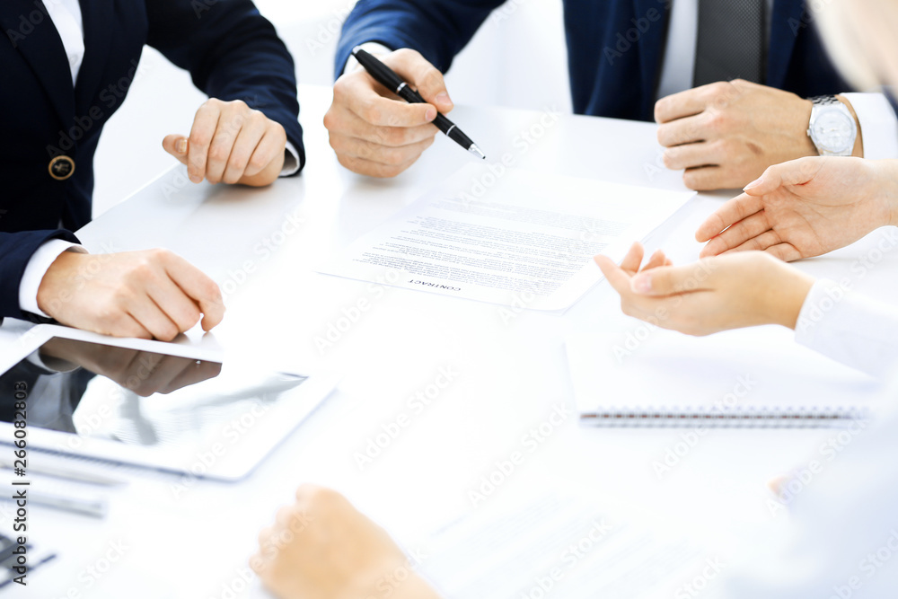 Group of business people and lawyers discussing contract papers sitting at the table, close-up. Successful teamwork, cooperation and agreement concepts Group of business people and lawyers discussing contract papers sitting at the table, close-up. Successful teamwork, cooperation and agreement concepts