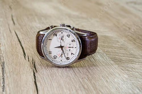 men's, wristwatches with a strap on a wooden background. Close-up.