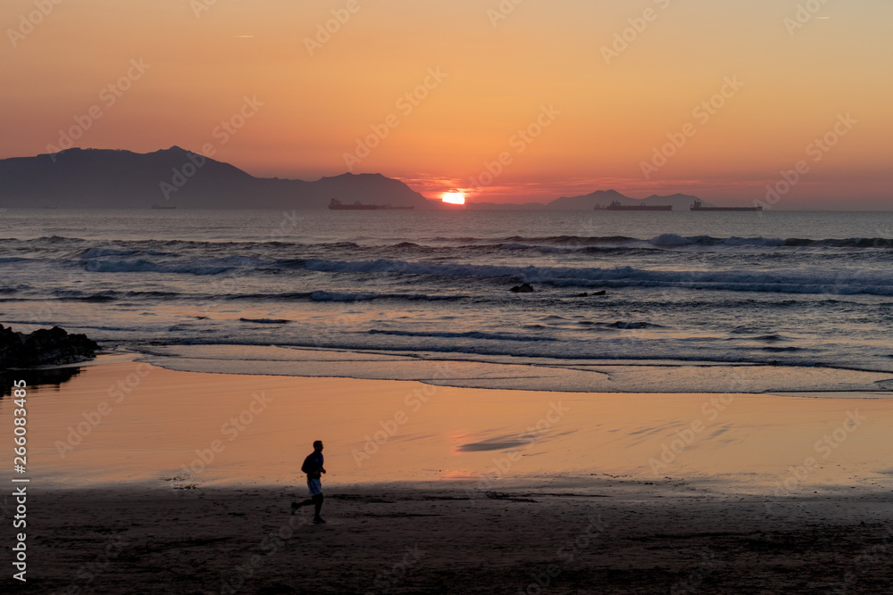 Sunset on the Atxabiribil beach, relax, peace and tranquility with the silhouette of a man running