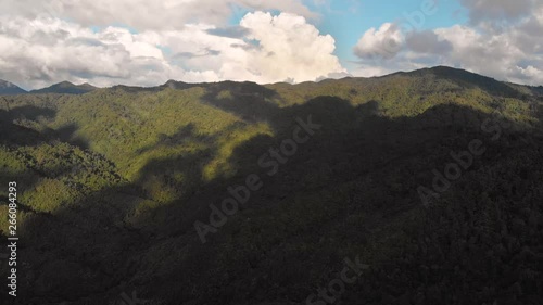 200% SPEED Aerial moving left shot over the lush green mountains with the shadow of clouds in the Coromandel Peninsula New Zealand photo