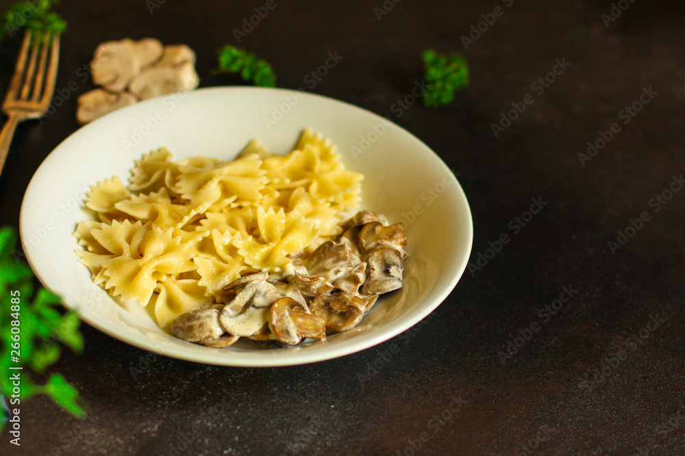 pasta farfalle with julienne mushrooms (fresh dish). food background. top
