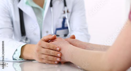 Hand of a doctor woman reassuring to female patient, close-up. Medical ethics and trust concept © rogerphoto