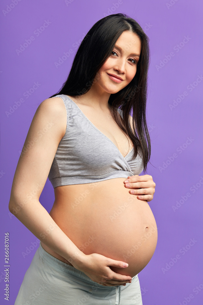 Pregnant woman with almost 9 months of exciting expectations behind, holds her tummy, expecting exciting moments of meeting with the miracle- her child. Pregnant woman with almost 9 months of exciting expectations behind, holds her tummy, expecting exciting moments of meeting with the miracle- her child.