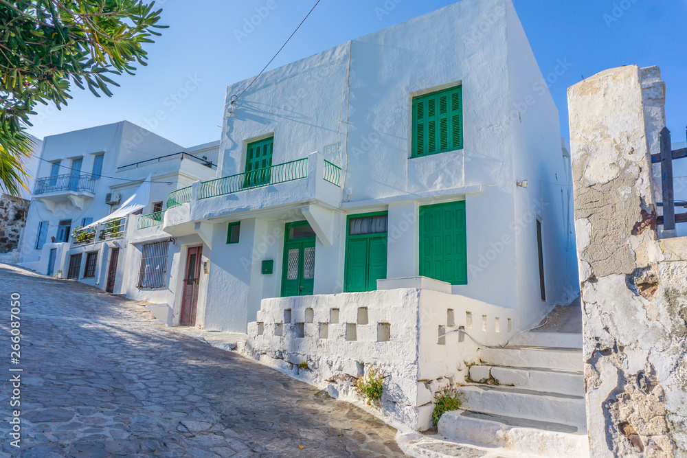 Street view of Plaka picturesque village with paved alleys and traditional houses in Milos island in Cyclades, Greece