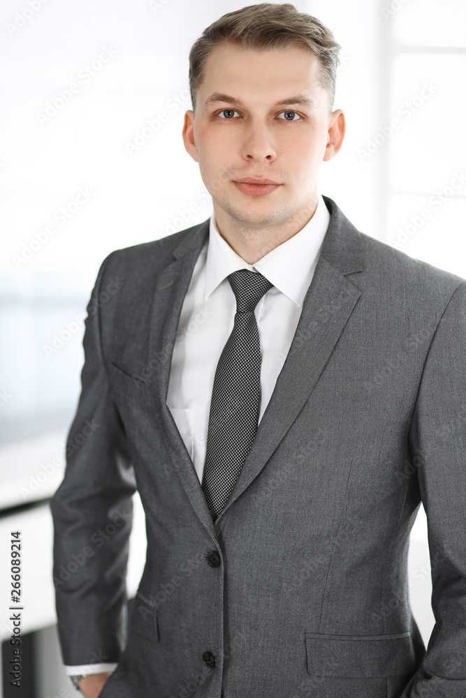 Headshot of businessman standing straight in office. Success and business workplace concept Headshot of businessman standing straight in office. Success and business workplace concept