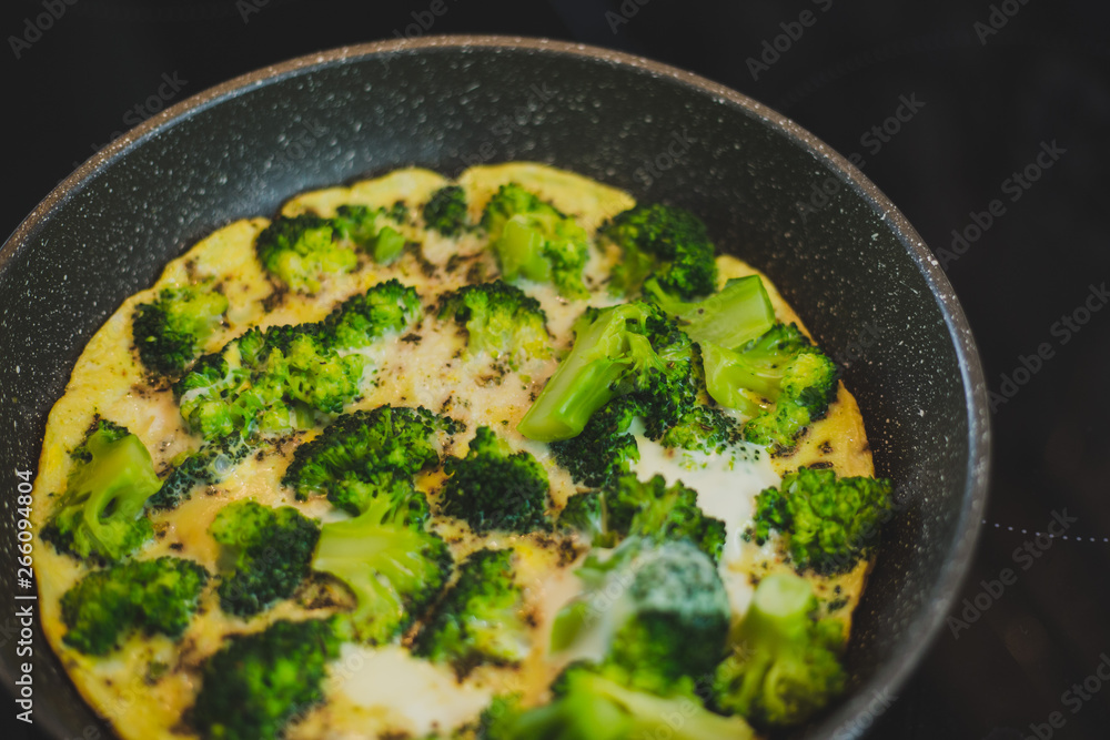 cooking broccoli with eggs in a frying pan cooking broccoli with eggs in a frying pan