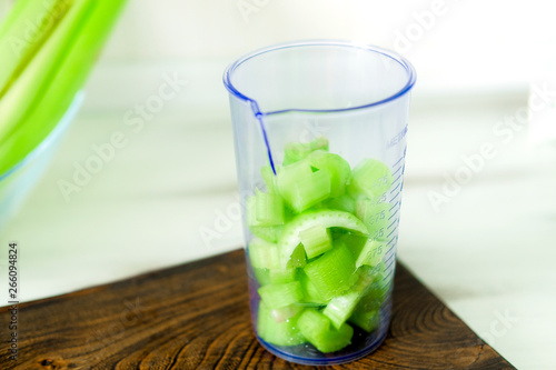 Cut green celery stalk slices in measuring jar. Healthy vegan diet