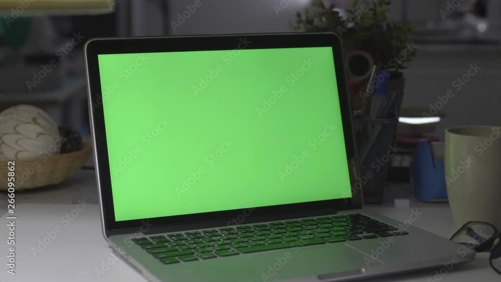 Laptop with green screen. Dark office. Dolly shot. Perfect to put your own image or video. Laptop with green screen. Dark office. Dolly shot. Perfect to put your own image or video.