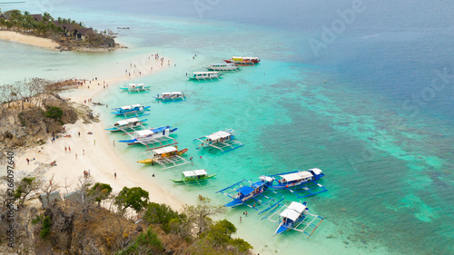 People relax on island.Many tourist boats on coast of tropical island.