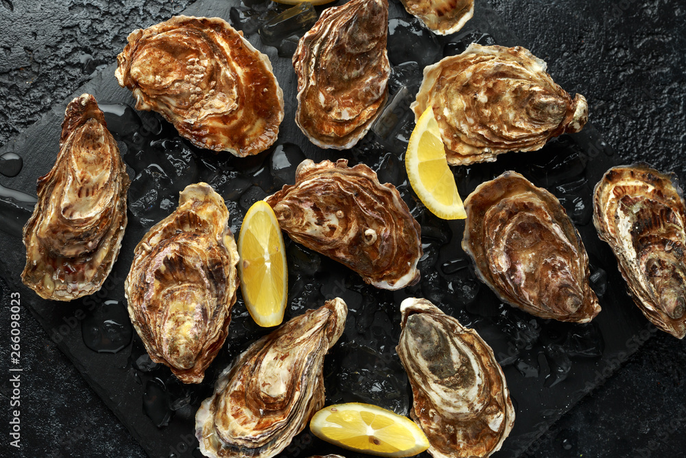 Fresh Oysters platter with lemon and ice. ready to open and eat Fresh Oysters platter with lemon and ice. ready to open and eat