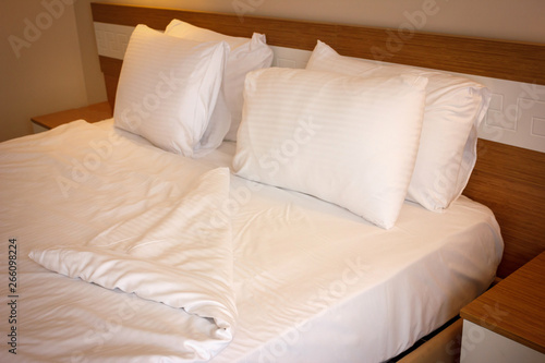 Double bed with white linens, prepared for bedtime sleeping