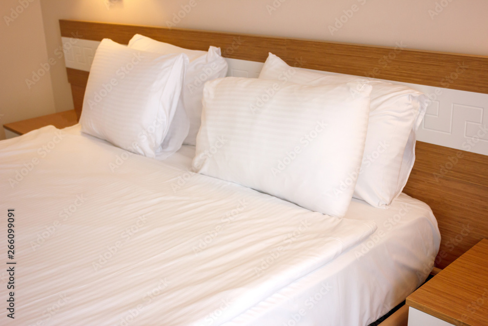 Double bed with white linens, prepared for bedtime sleeping