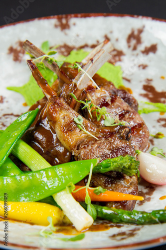Roasted lamb chops with green pea purée, baby vegetables and classic mint sauce