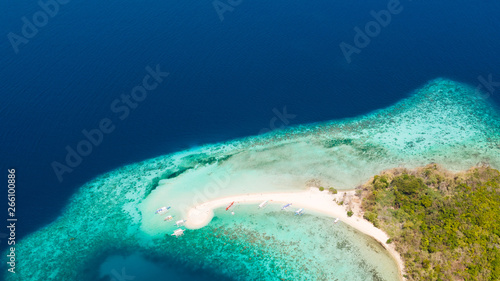 Tropical island with coral reefs and a white beach, view from the top.Azure sea and white sand.