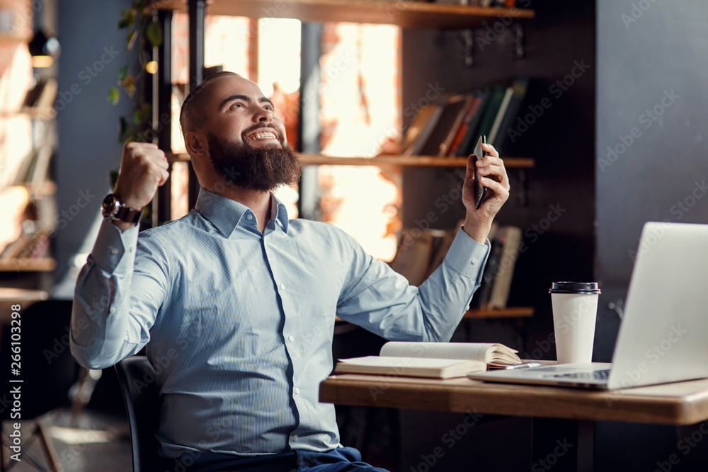 Fototapeta premium Euphoric happy businessman scream read good online news celebrating business success, great result watching game on laptop, excited by victory, betting win, professional achievement, feeling winner