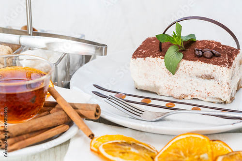 A piece of cake on a served table with tea