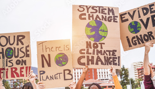 Group of demonstrators on road, young people from different culture and race fight for climate change - Global warming and enviroment concept - Focus on banners photo