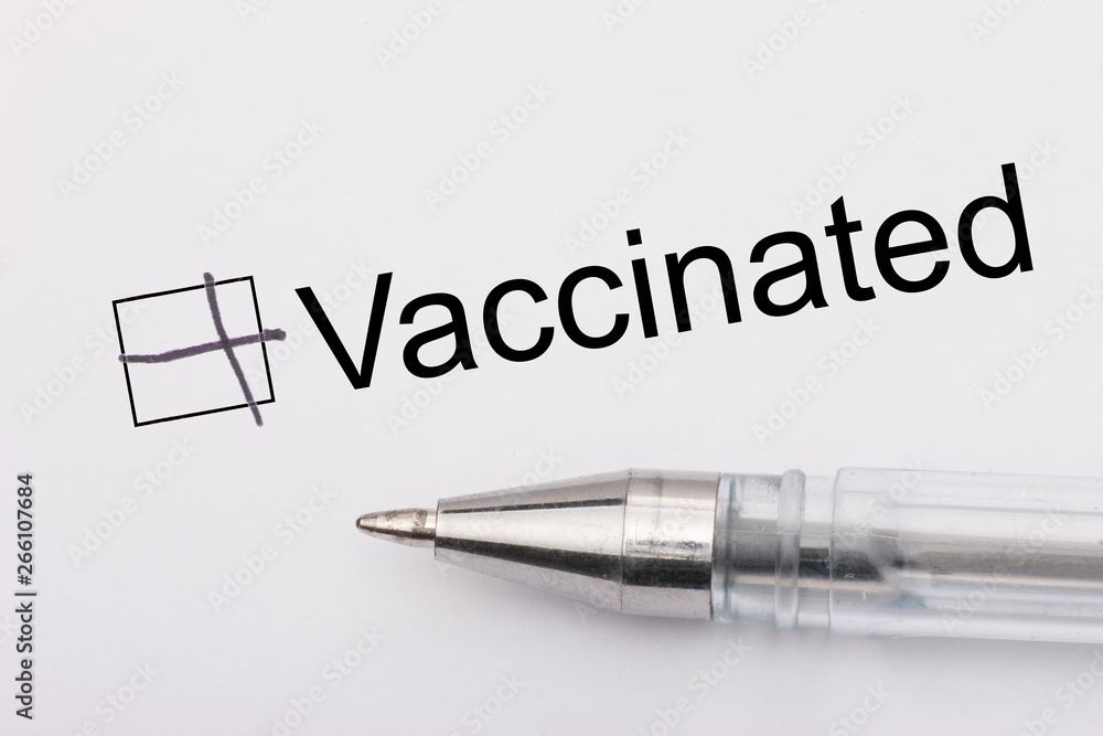 Vaccinated - checkbox with a cross on white paper with pen. Checklist concept. Vaccinated - checkbox with a cross on white paper with pen. Checklist concept.