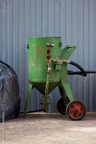 Obraz na plátně worker green old air sand blower Sandblast stands near the fence next to the Gatchina Palace