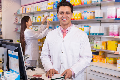 Pharmacist standing at pay desk photo