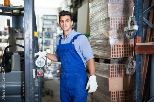 Portrait of calm male in uniform on his workplace in building store.