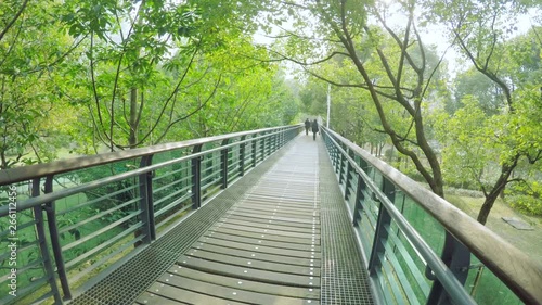 Raised wooden walkway in Xujiahui park Shanghai. In Xuhui park, an elevated wooden and glass walkway above the park, crossing it from one side to the other. photo