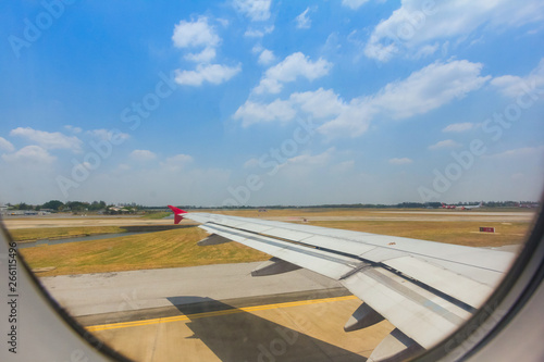 Aircraft wing view from inside plane with airport