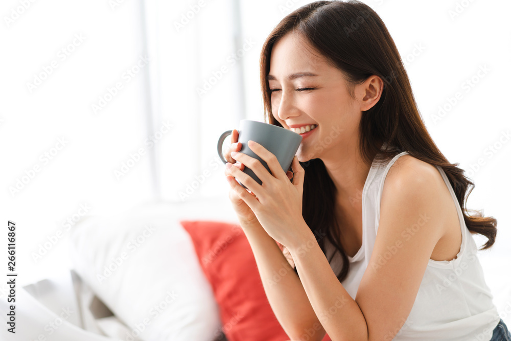 Woman drinking coffee in bedroom in the morning Woman drinking coffee in bedroom in the morning