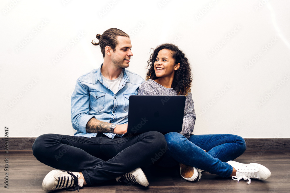Happy smiling couple sitting relax working and use technology together of laptop computer on white wall background Happy smiling couple sitting relax working and use technology together of laptop computer on white wall background